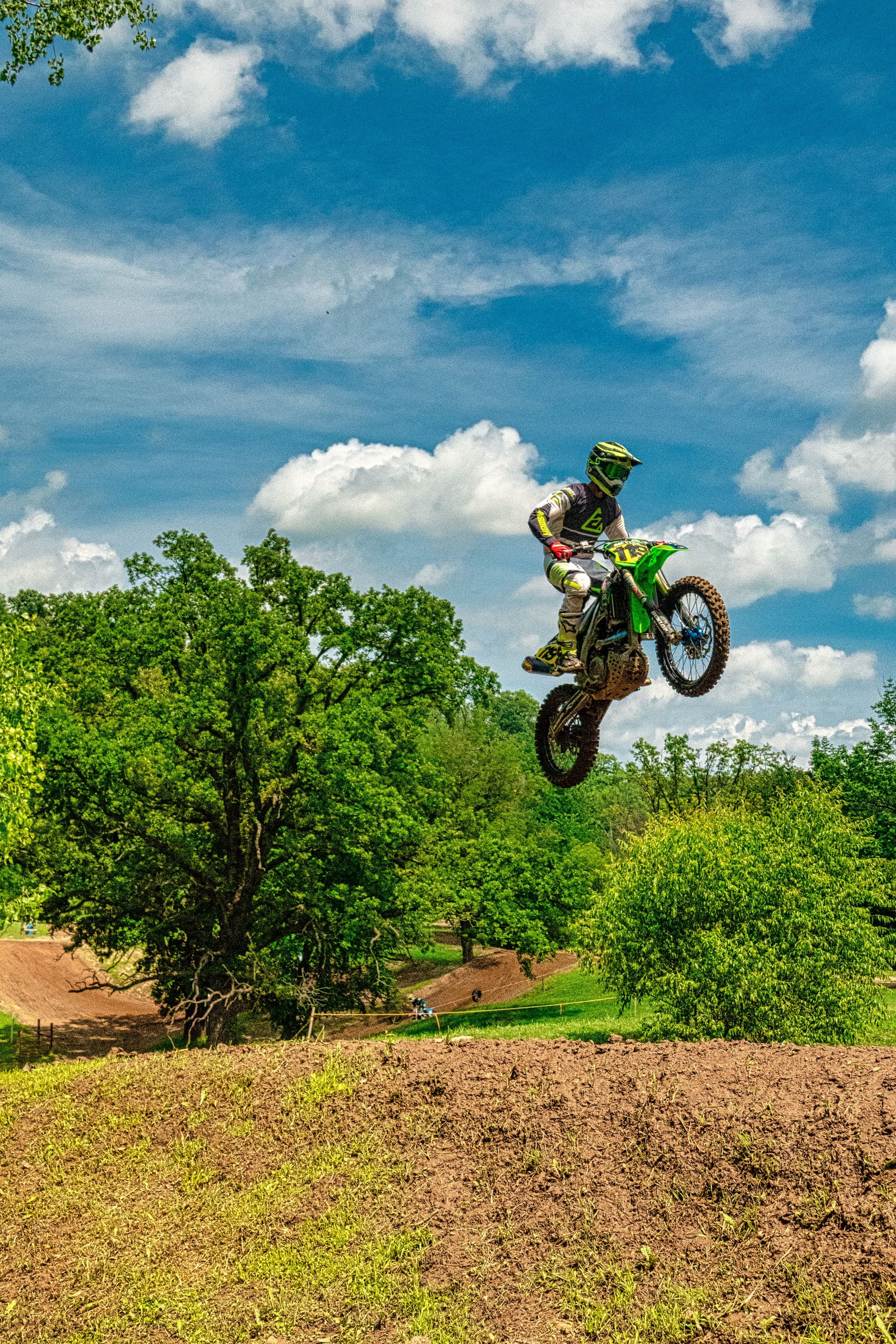 Pilote de motocross en saut sur une piste en terre