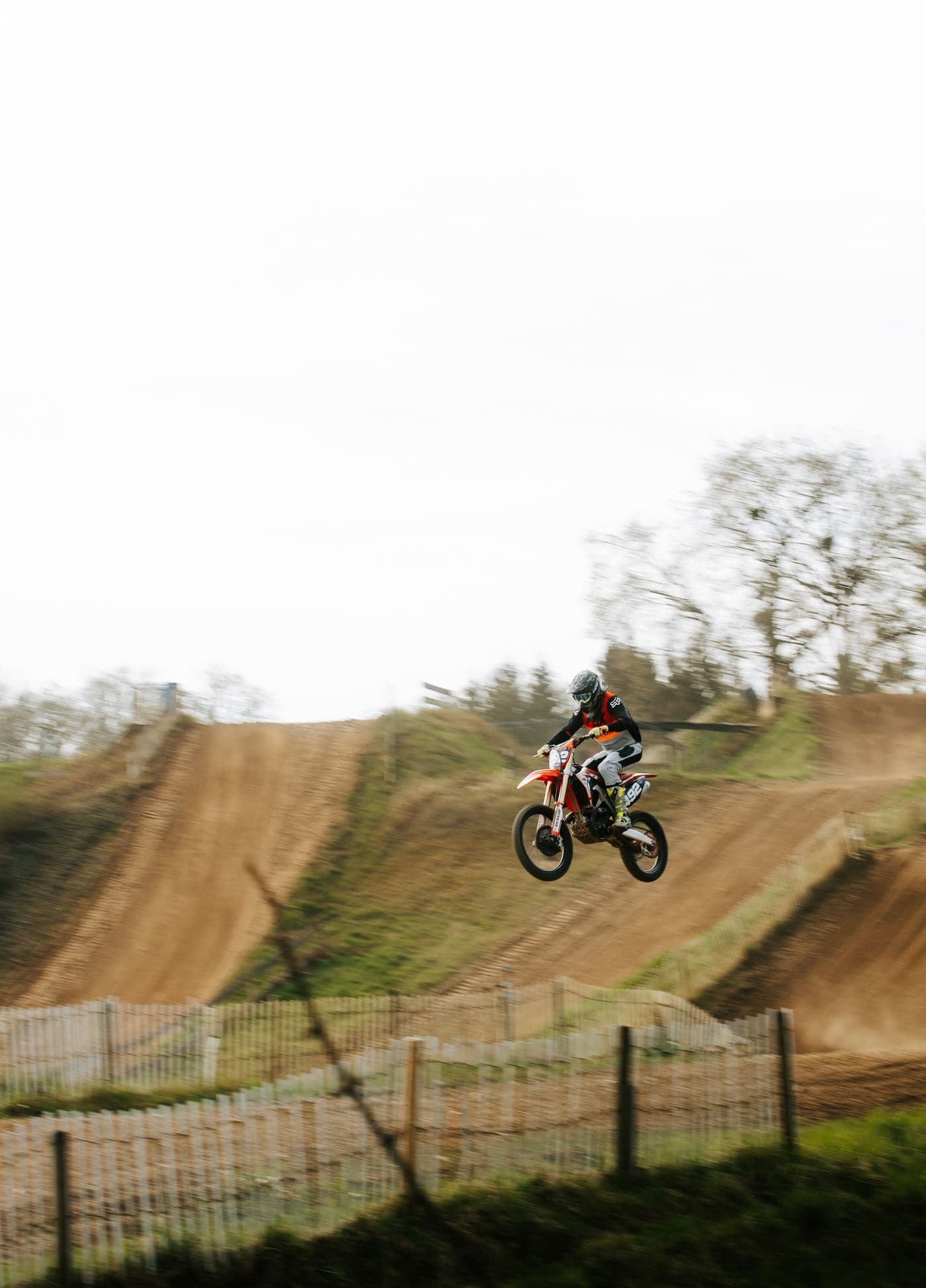 Pilote de motocross en saut sur une piste en terre